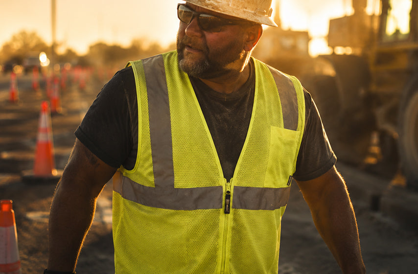 Worker wearing reflective safety vest on a low-light job site 