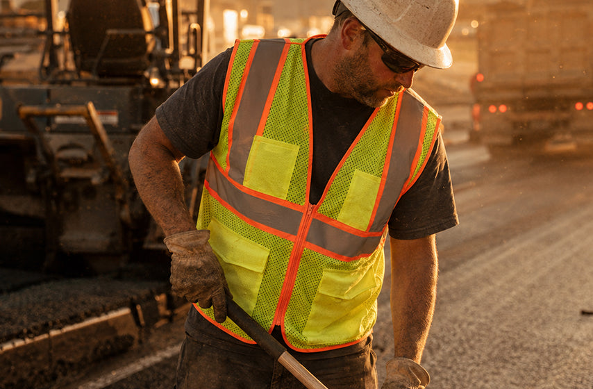 Road construction workers wearing high visibility safety apparel on active roadway